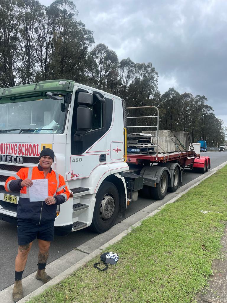 man posing with his truck driving certificate