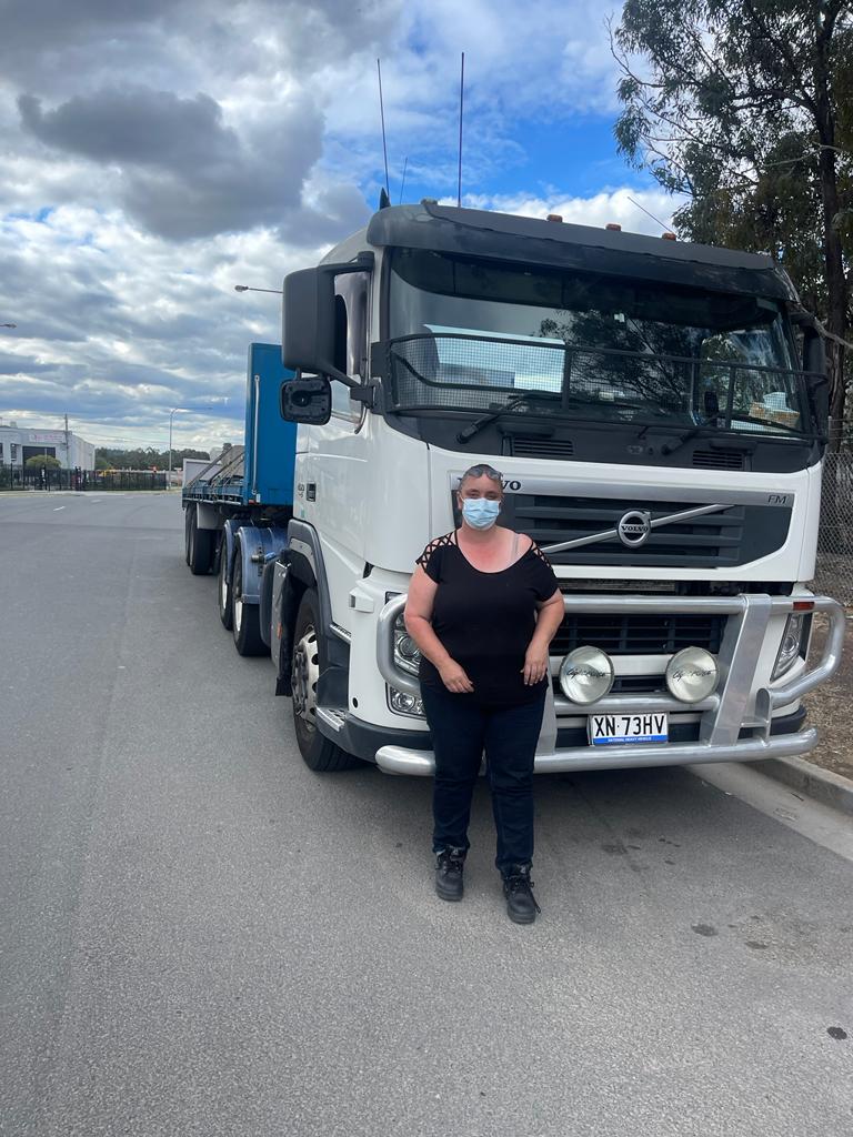 Caucasian lady in front of a truck