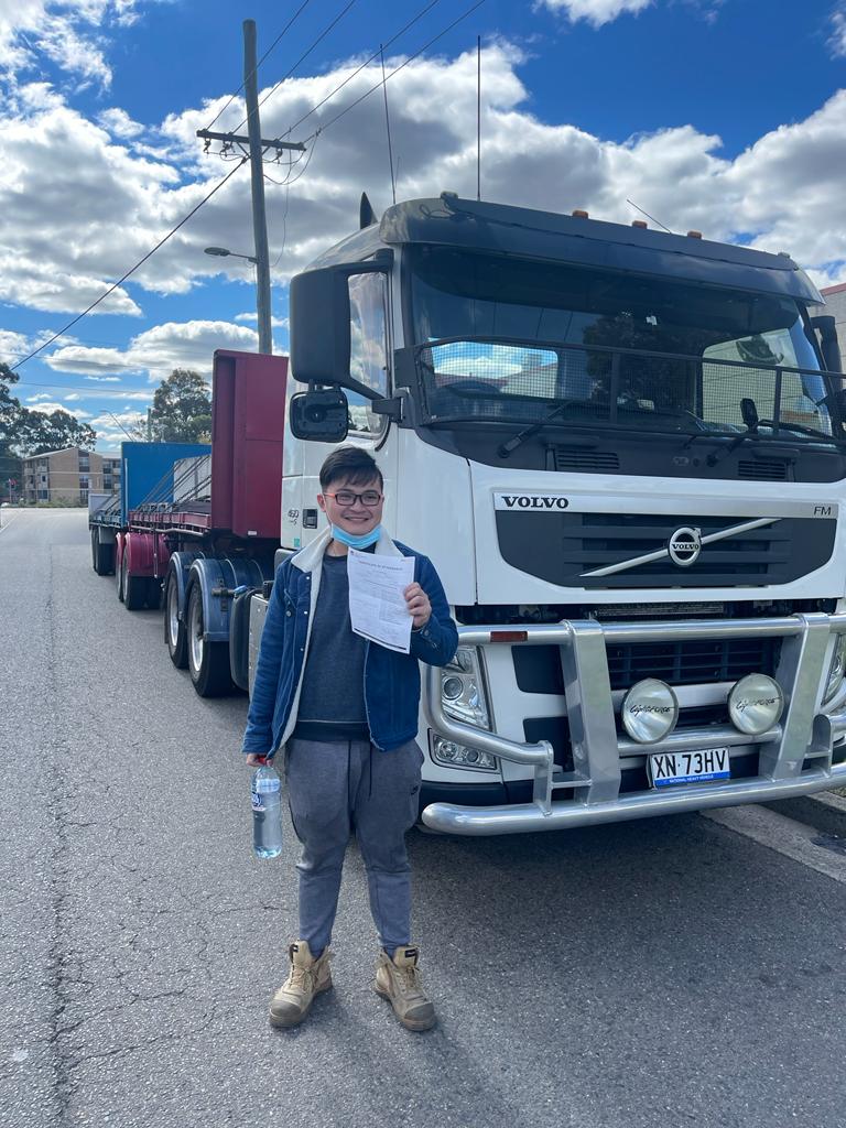 Asian man posing with his truck driving certificate