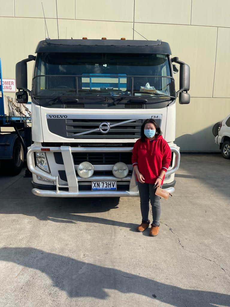 asian lady posing in front of a truck